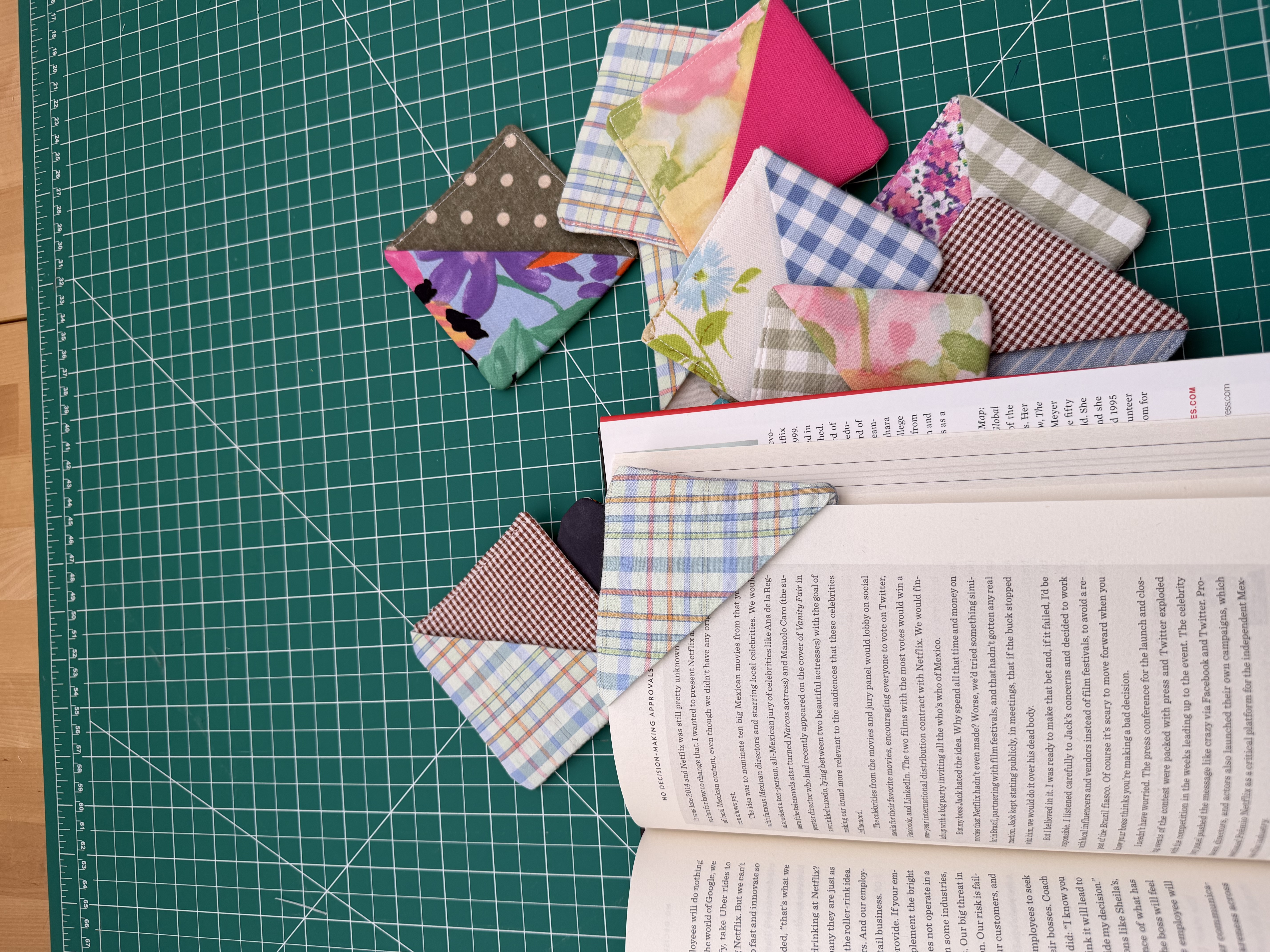 Four finished fabric corner bookmarks stacked together
